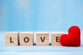 LOVE wooden cubes with red heart shape decoration on blue table background and copy space for text. Love, Romantic and Happy Royalty Free Stock Photo